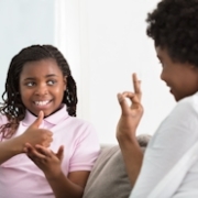 Junge Mutter kommuniziert in Zeichensprache mit ihrer Tochter