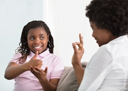 Junge Mutter kommuniziert in Zeichensprache mit ihrer Tochter